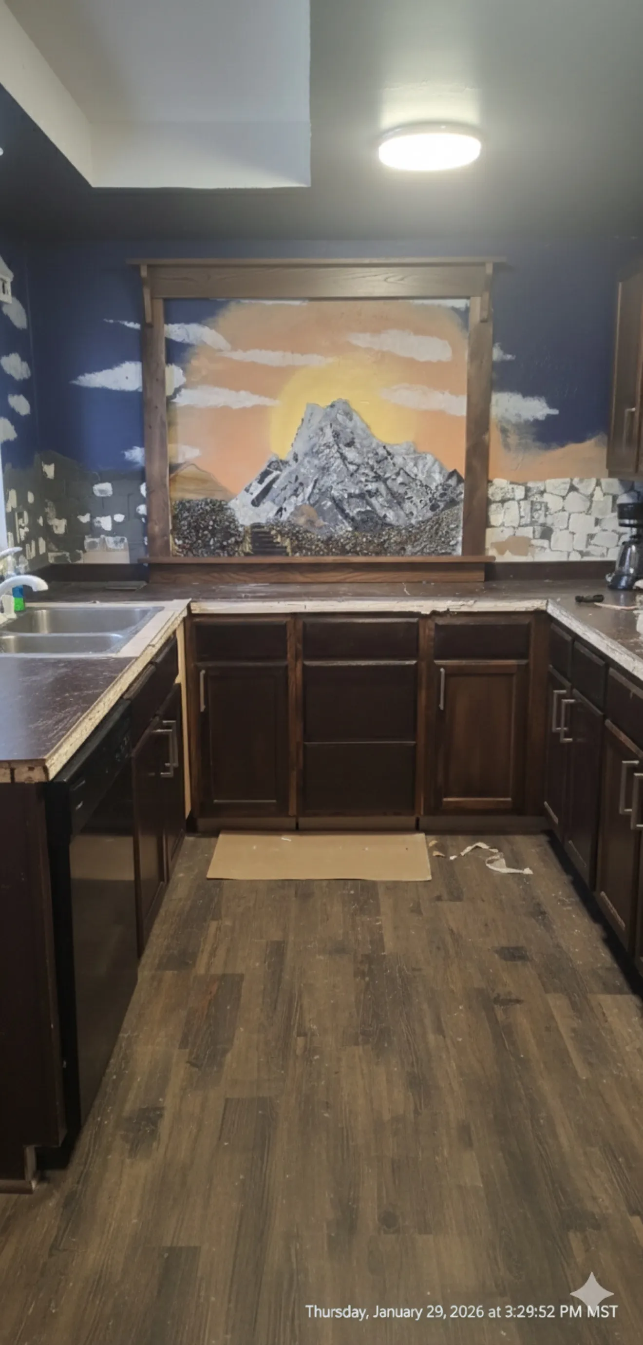 Hand-cut glass mountain mural taking shape on a kitchen wall